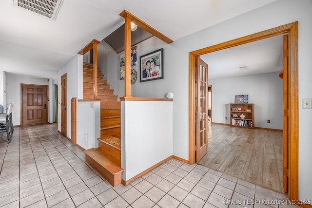 stairway featuring baseboards, tile patterned flooring, and visible vents