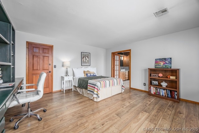 bedroom with wood finished floors, baseboards, and visible vents