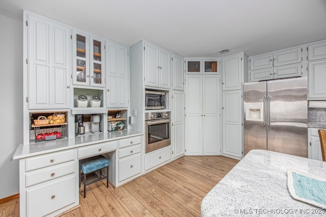 kitchen with light wood-style floors, light countertops, and stainless steel appliances