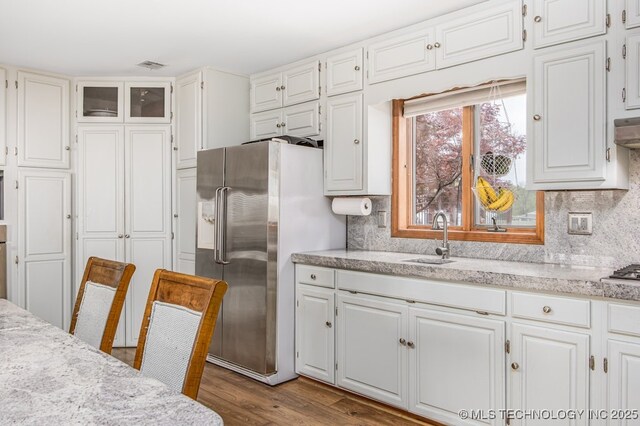kitchen featuring a sink, white cabinets, and stainless steel refrigerator with ice dispenser
