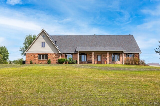 view of front of house featuring a front yard and brick siding