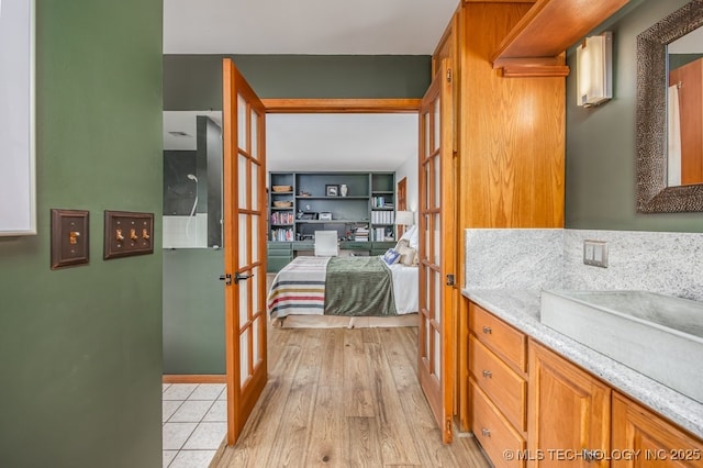 bathroom featuring french doors, connected bathroom, vanity, and wood finished floors