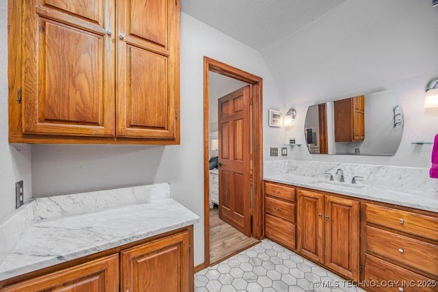 bathroom with vanity, tile patterned flooring, and lofted ceiling