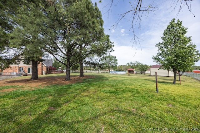 view of yard with a pool and fence