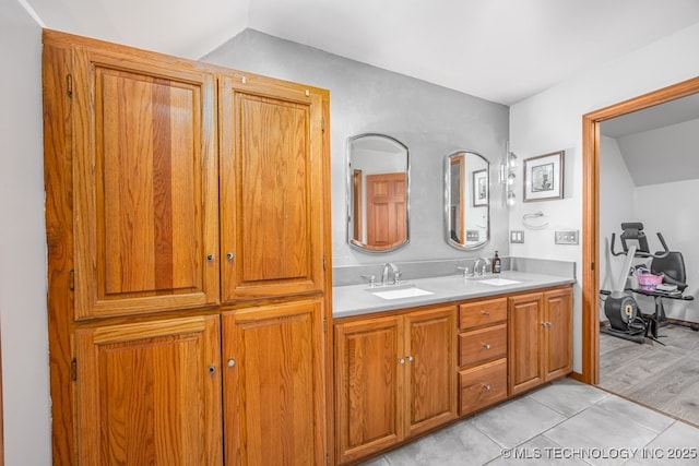 bathroom featuring tile patterned flooring, double vanity, vaulted ceiling, and a sink