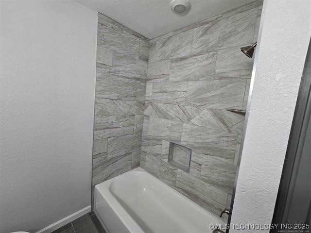 full bath with bathing tub / shower combination and baseboards