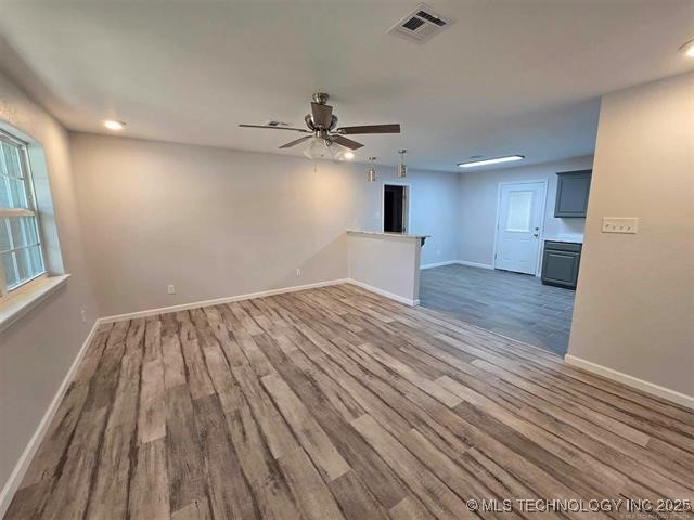 spare room featuring ceiling fan, visible vents, recessed lighting, wood finished floors, and baseboards