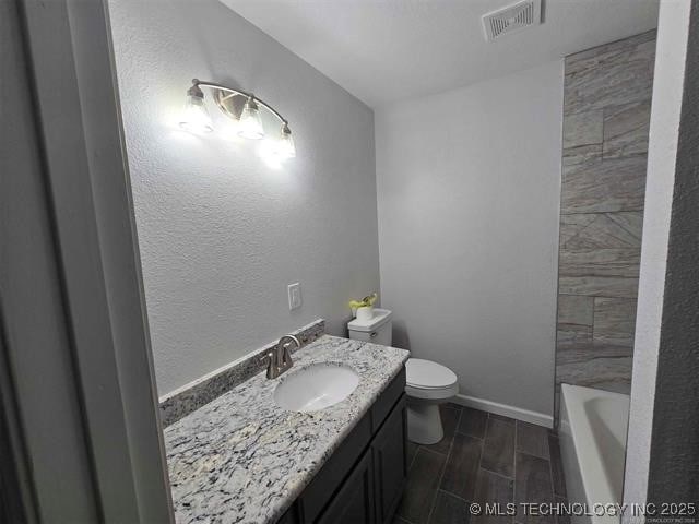 bathroom with vanity, a tub, toilet, visible vents, and a shower