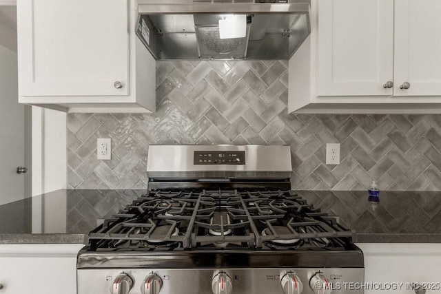 kitchen featuring stainless steel gas stove, wall chimney range hood, backsplash, and white cabinets