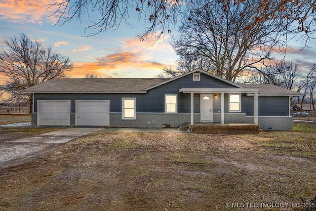 ranch-style home with a shingled roof, a garage, driveway, and brick siding