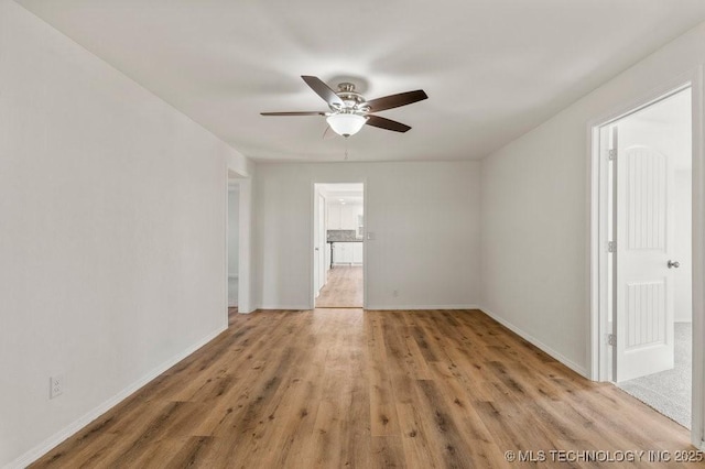 unfurnished room with ceiling fan, light wood-type flooring, and baseboards