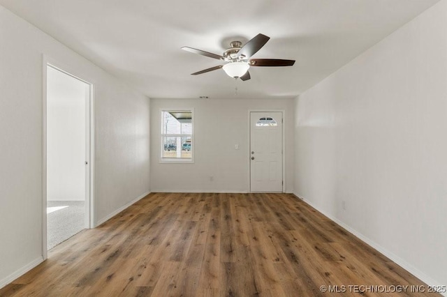 unfurnished room with baseboards, a ceiling fan, and wood finished floors