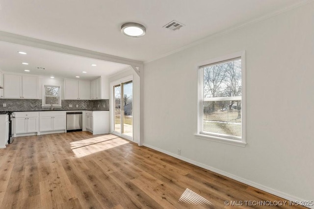 kitchen featuring tasteful backsplash, visible vents, dark countertops, crown molding, and white cabinetry