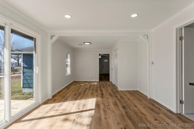 hallway featuring a healthy amount of sunlight, wood finished floors, and baseboards