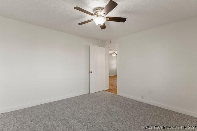 carpeted empty room featuring a textured ceiling, baseboards, and a ceiling fan