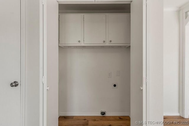 clothes washing area with cabinet space, baseboards, hookup for an electric dryer, and wood finished floors