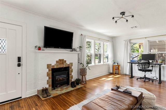 1235 S Atlanta Pl, Tulsa, OK 74104 - living room with baseboards, crown molding, a wood stove, visible vents, and wood finished floors