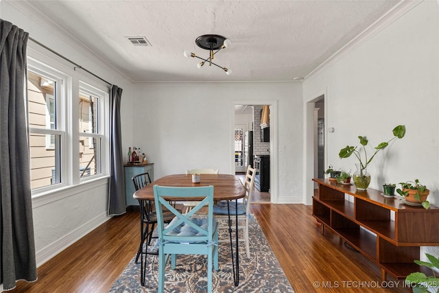 1235 S Atlanta Pl, Tulsa, OK 74104 - dining space with crown molding, a textured ceiling, visible vents, wood finished floors, and baseboards