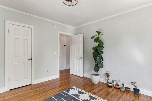 1235 S Atlanta Pl, Tulsa, OK 74104 - unfurnished bedroom featuring baseboards, crown molding, and wood finished floors
