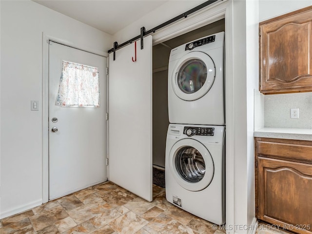 338 E 45th Pl, Tulsa, OK 74105 - laundry room with estacked washer and dryer, a barn door, and stone finish flooring