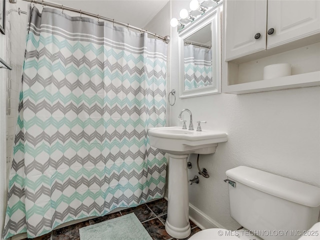 bathroom featuring toilet and curtained shower
