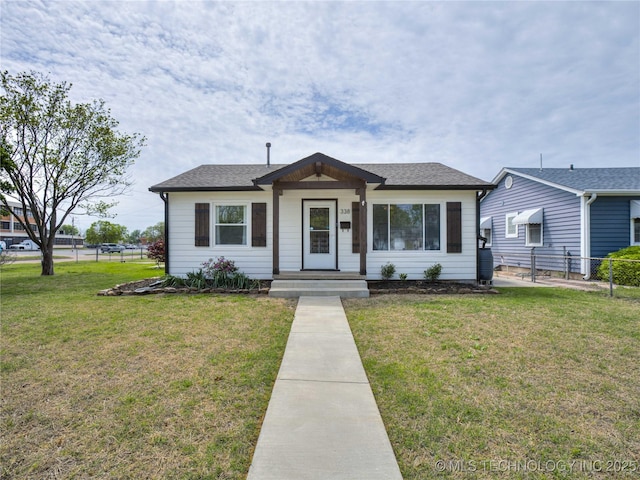 bungalow-style house featuring a front lawn and fence