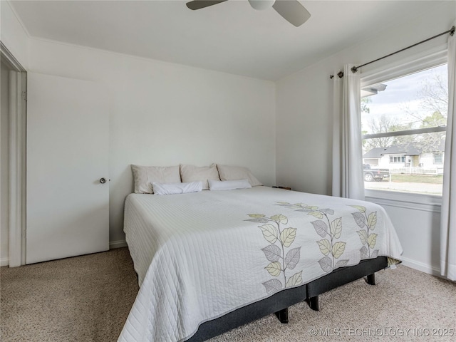 carpeted bedroom featuring baseboards and a ceiling fan