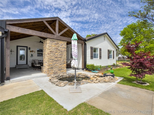 exterior space featuring a patio, ceiling fan, and a front lawn