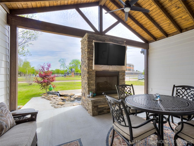view of patio / terrace featuring an outdoor stone fireplace, a ceiling fan, and outdoor dining area