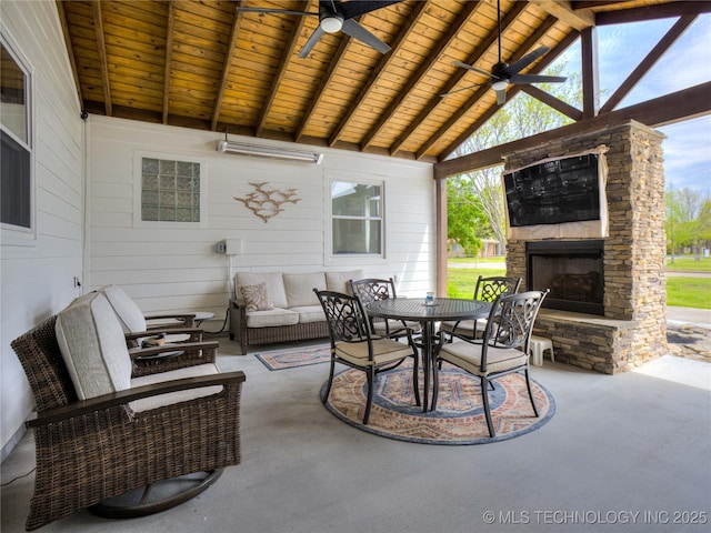 view of patio / terrace featuring a ceiling fan, an outdoor living space with a fireplace, and outdoor dining space