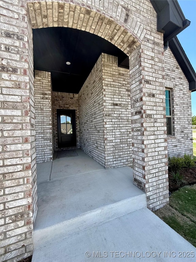 property entrance featuring brick siding