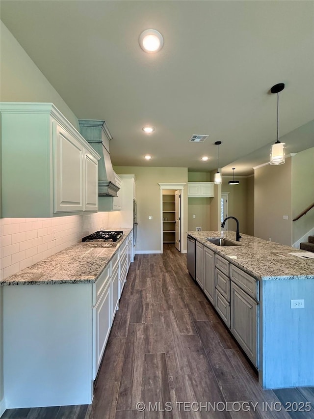 kitchen with appliances with stainless steel finishes, white cabinets, a sink, dark wood-style floors, and visible vents