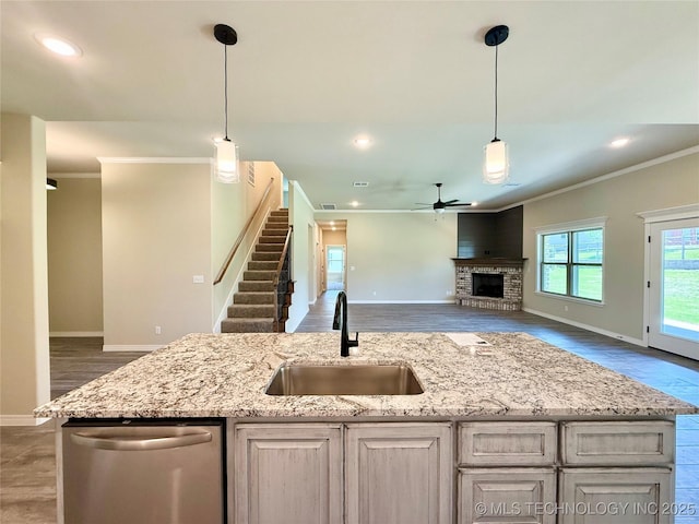 kitchen featuring crown molding, baseboards, a ceiling fan, and a sink
