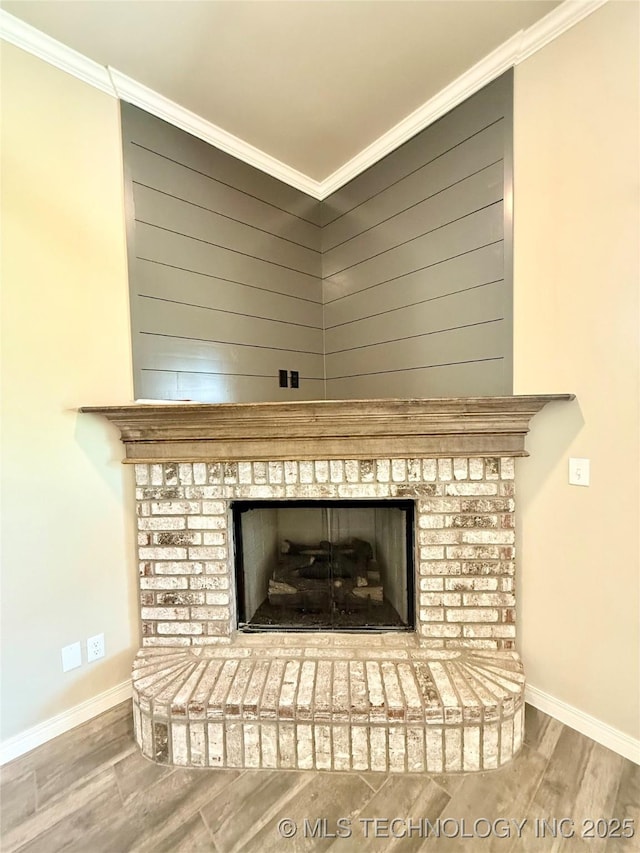 details with baseboards, wood finished floors, ornamental molding, and a brick fireplace