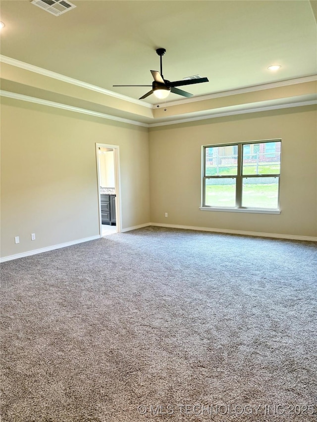 carpeted spare room with baseboards, a raised ceiling, ceiling fan, and ornamental molding