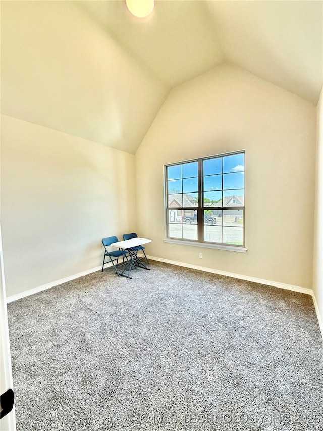 interior space featuring vaulted ceiling, carpet floors, and baseboards