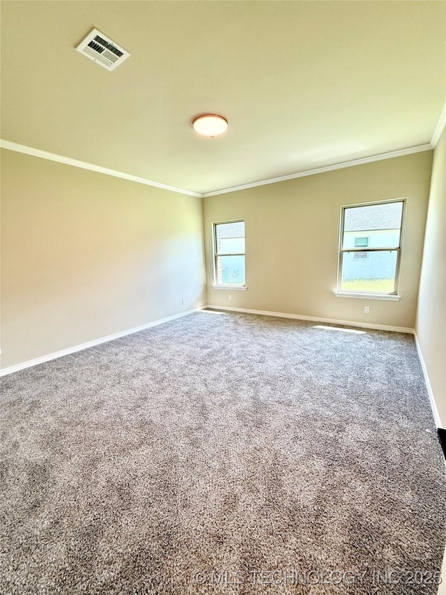 unfurnished room with visible vents, crown molding, carpet flooring, and baseboards