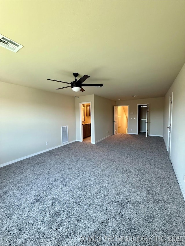 carpeted empty room featuring a ceiling fan, visible vents, and baseboards