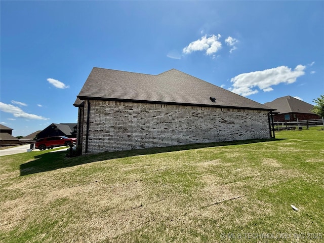 view of property exterior with brick siding and a yard