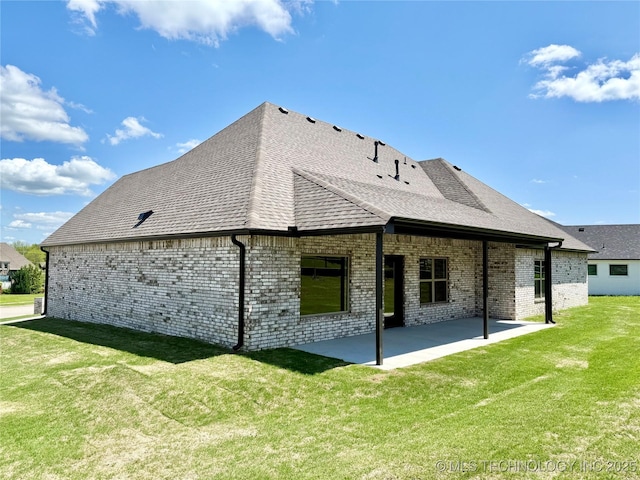 back of property with a patio area, a yard, a shingled roof, and brick siding