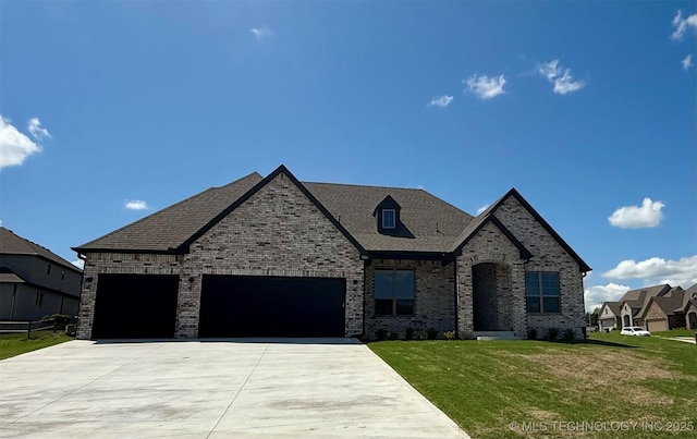 french country inspired facade with brick siding, a front lawn, driveway, and an attached garage