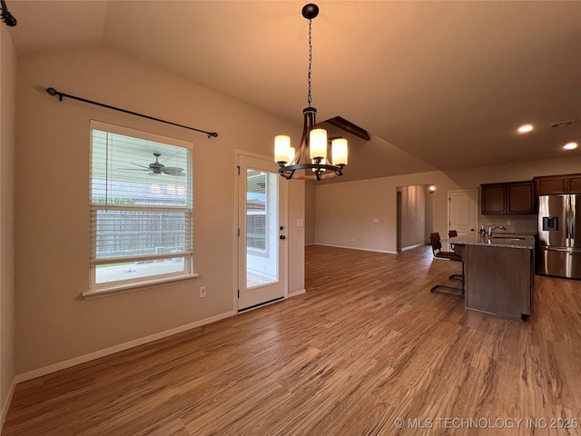 6370 E 124th Ct, Bixby, OK 74008 - kitchen with stainless steel refrigerator with ice dispenser, vaulted ceiling, a chandelier, open floor plan, and light wood-style floors