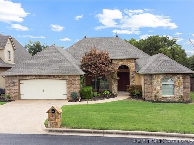 french provincial home featuring concrete driveway, stone siding, a front yard, a garage, and a shingled roof