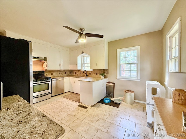 kitchen with tasteful backsplash, appliances with stainless steel finishes, a ceiling fan, and a healthy amount of sunlight