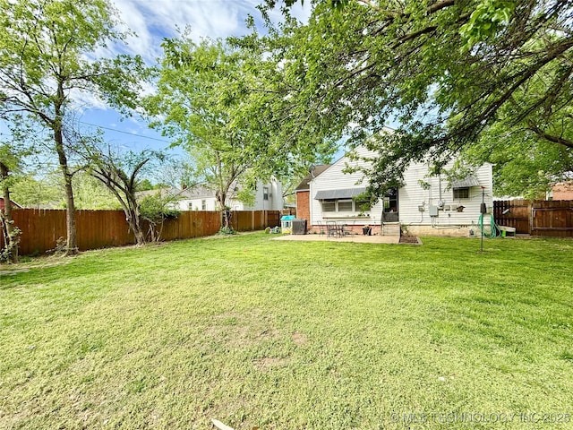 view of yard with a patio area, a fenced backyard, and cooling unit
