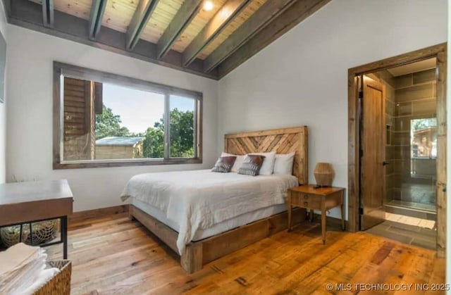 bedroom featuring wood ceiling, wood finished floors, ensuite bath, and vaulted ceiling with beams