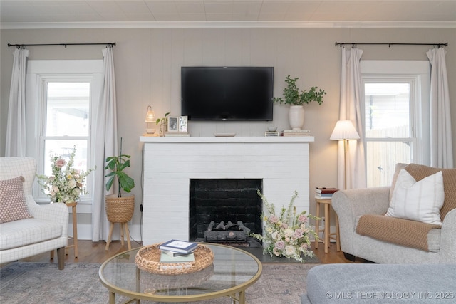 511 N Main St, Sand Springs, OK 74063 - living room featuring wood finished floors, ornamental molding, plenty of natural light, and a brick fireplace