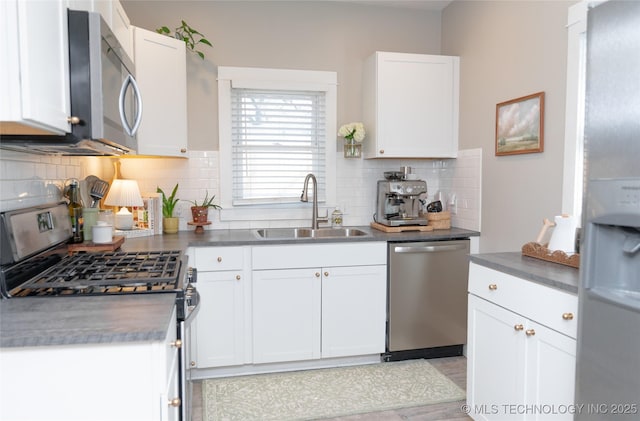 511 N Main St, Sand Springs, OK 74063 - kitchen featuring appliances with stainless steel finishes, a sink, decorative backsplash, white cabinetry, and dark countertops