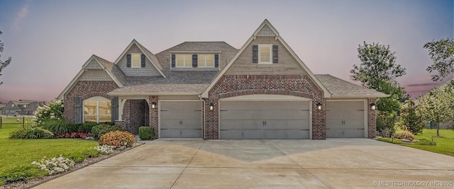 11439 N 162nd E Ave, Owasso, OK 74055 - view of front of house with brick siding, concrete driveway, a lawn, an attached garage, and roof with shingles