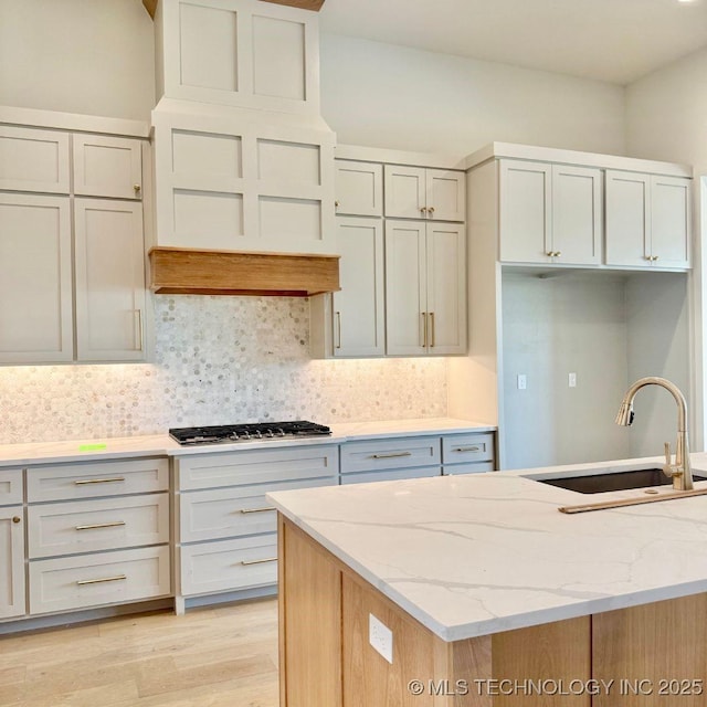 17806 S 46 E Ave, Bixby, OK 74008 - kitchen featuring a sink, stainless steel gas stovetop, tasteful backsplash, and light wood finished floors